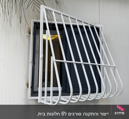 סורגי מתכת לבנים על חלון קיר חיצוני